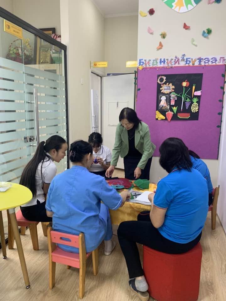 A teacher reading a picture book to young children